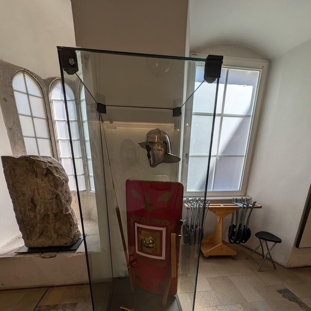 Roman helmet, shield and spear in a glass case.